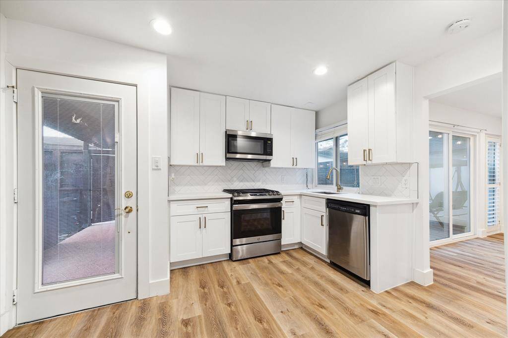 Guest quarters, with a private entrance and access to the back patio and pool, feature a full kitchen, living area, and a full bathroom. The kitchen offers sleek stainless-steel appliances, Quartz countertops, and designer tile backsplash.