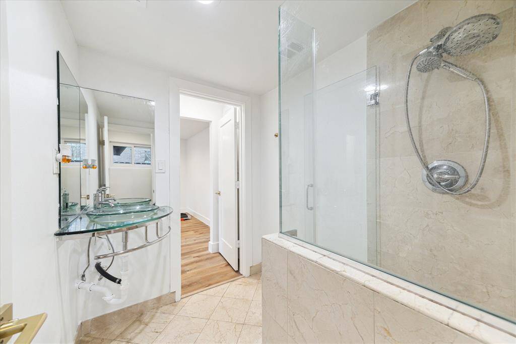 The guest quarters offer a full bathroom with a walk-in shower and modern floating single sink vanity.