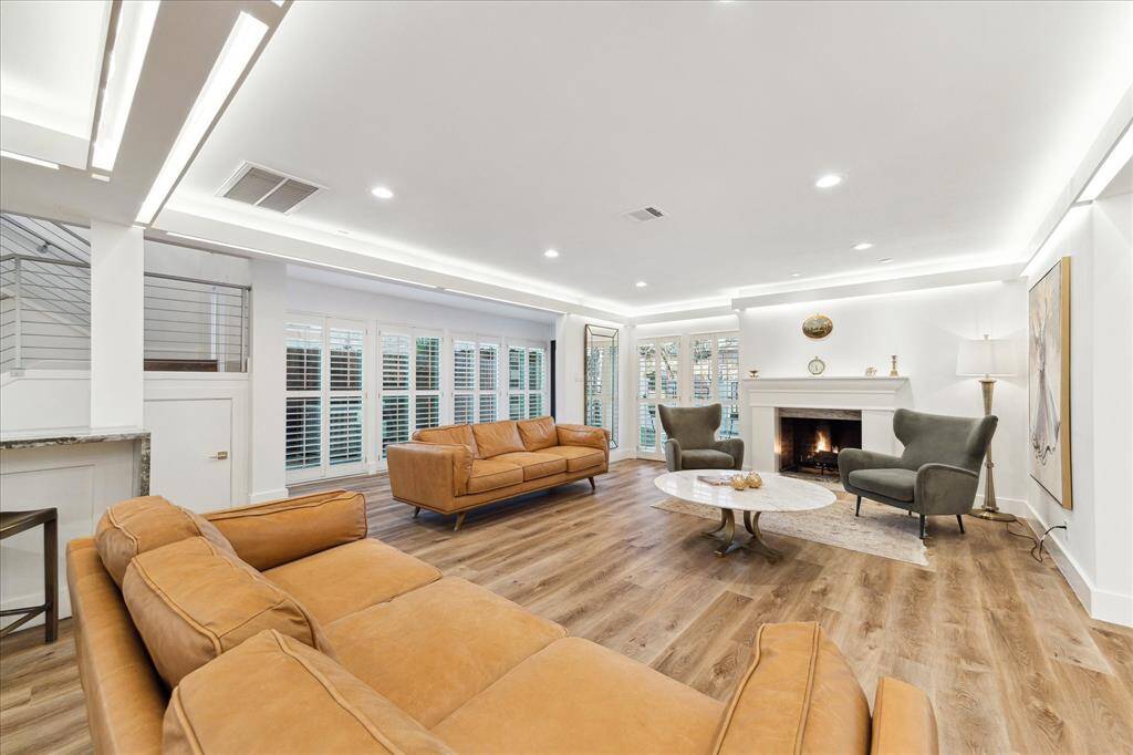 Modern sophistication meets everyday comfort in this beautifully designed home. Featuring stylish finishes and an open layout, it's perfect for entertaining or cozy nights by the fire. The inviting family room boasts LVP flooring, soft neutral paint, ambient lighting, wood-shuttered windows, and a romantic gas-log fireplace.