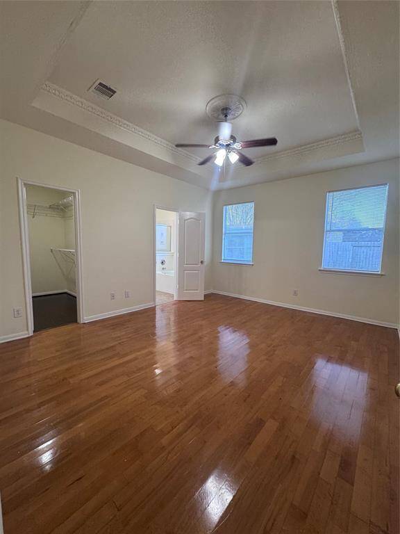 Primary bedroom downstairs with vaulted ceiling and fan