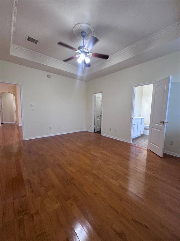 Primary bedroom downstairs with vaulted ceiling and fan