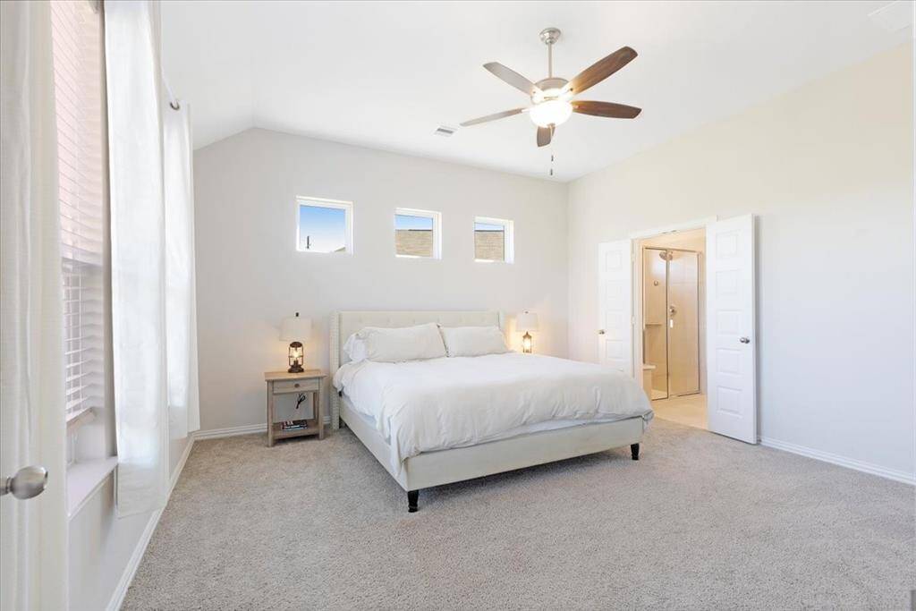Primary bedroom with windows overlooking the backyard pond view