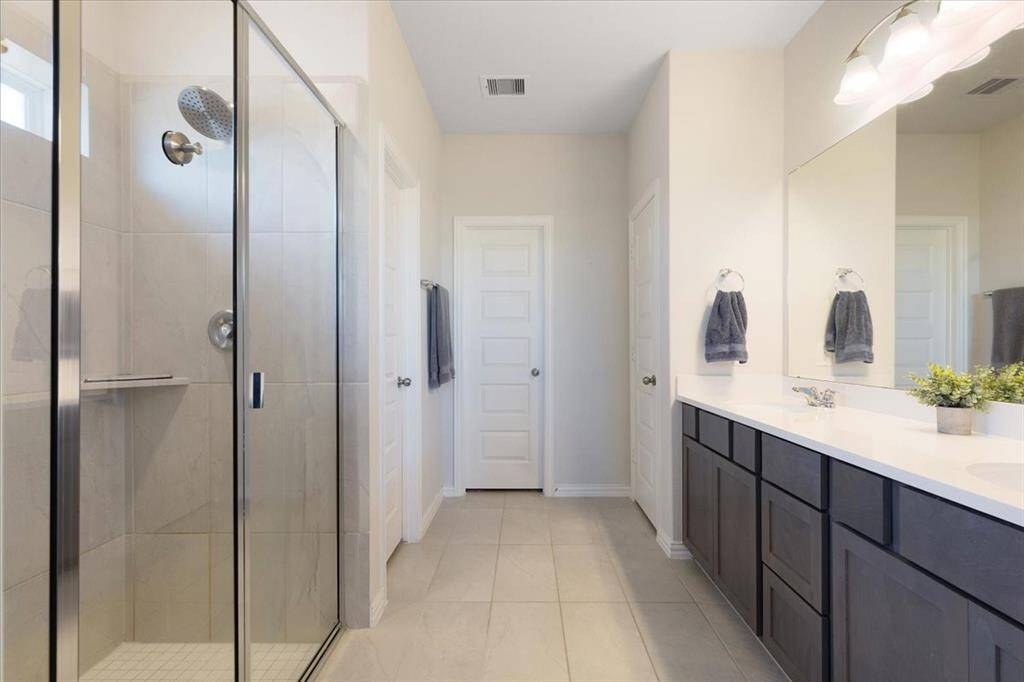 Ensuite primary bathroom with double sinks and a large walk-in shower