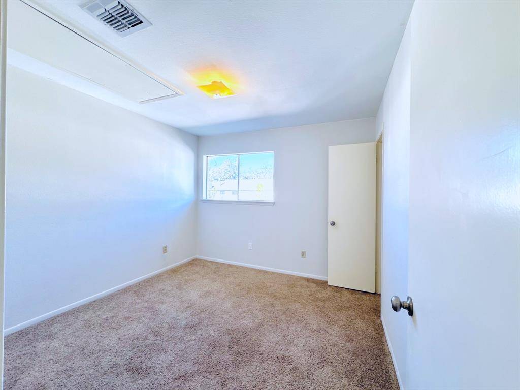 A generously sized bedroom with plush carpeting, offering comfort and warmth.