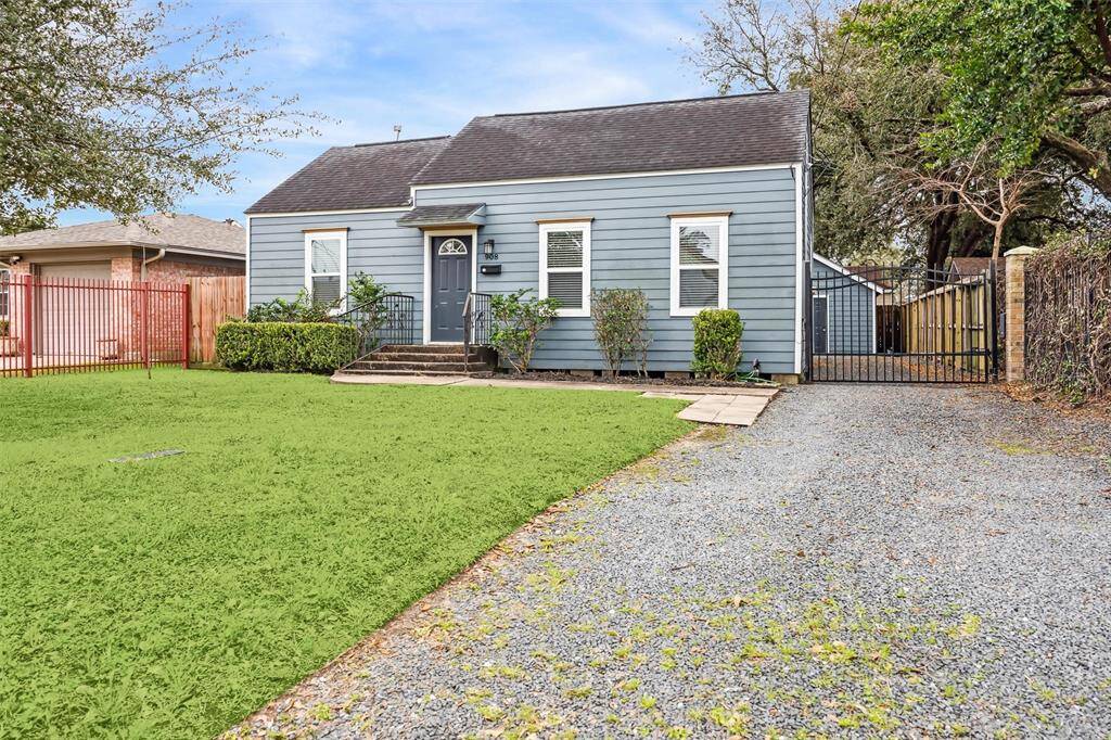 This photo features the spacious fenced backyard with well-maintained grass, surrounded by wooden fencing.