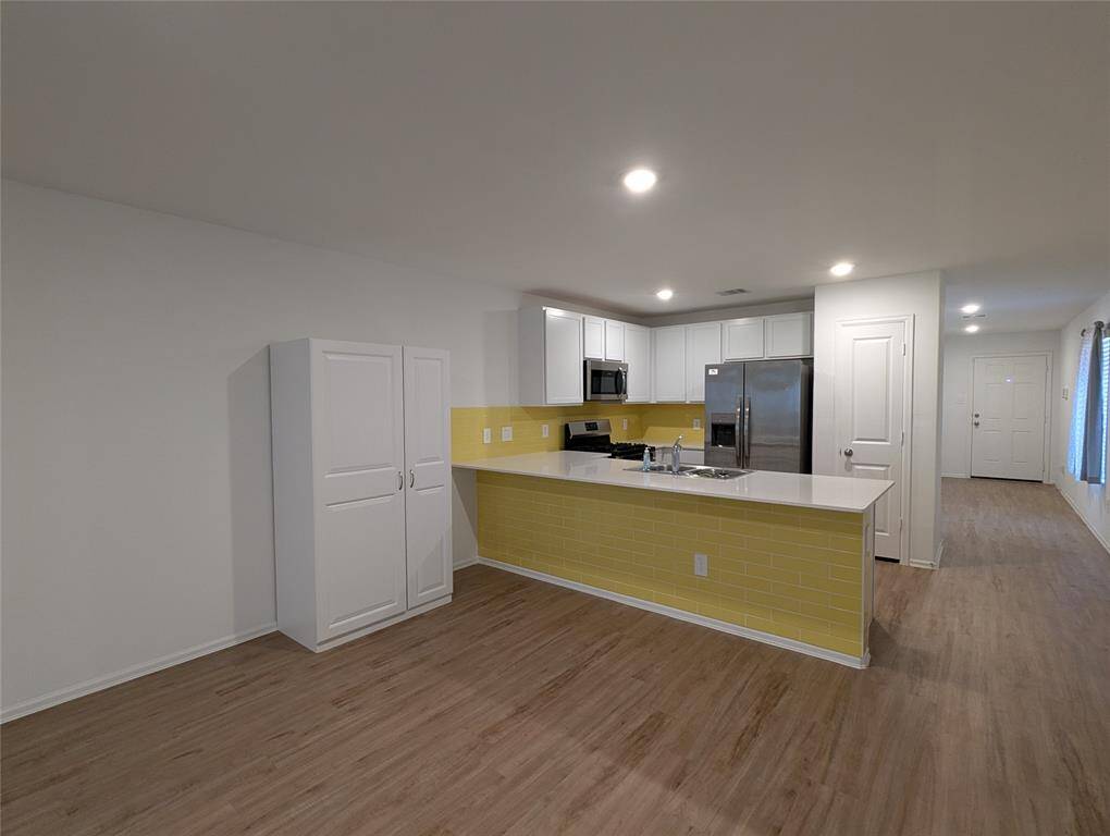 The kitchen and breakfast area have a counter with overhang for stools and an extra storage cabinet.