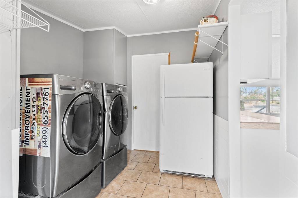 Utility Room witih washer, dryer and refridgerator.