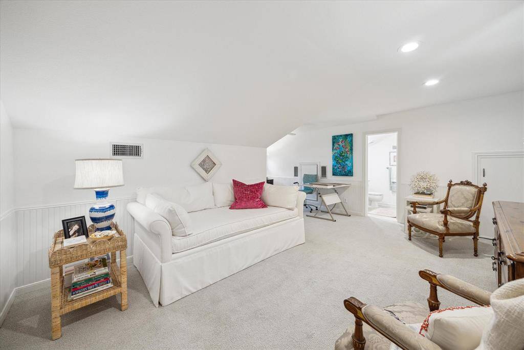 The upstairs 4th bedroom is well-lit with recessed lighting and includes a small desk area. Neutral carpeting and tasteful decor create a welcoming atmosphere.