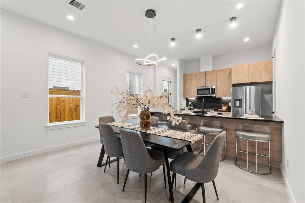 Stainless steel appliances, quartz countertops, and modern flat edge cabinetry throughout the kitchen.