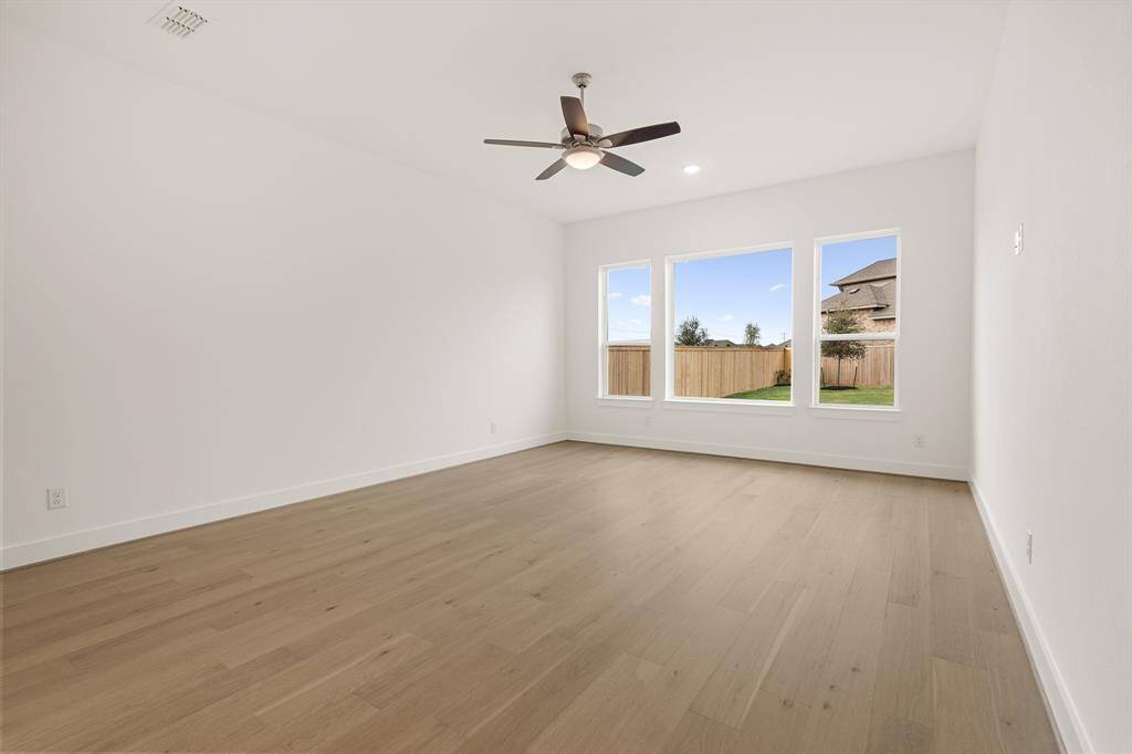 GENEROUS SIZED MAIN BEDROOM - LIGHT AND BRIGHT WITH LARGE WINDOWS -- WARM TONED WOOD FLOORING
