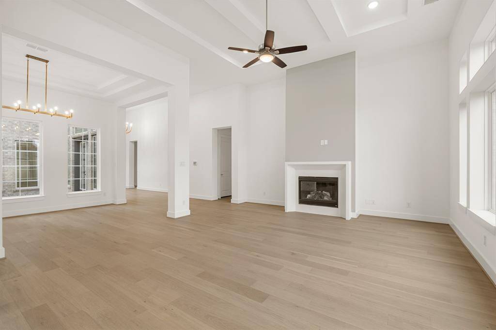 FAMILY ROOM WITH HIGH CEILINGS - OPEN TO FORMAL DINING - SLEEK FIREPLACE DESIGN - WOOD FLOORING THROUGHOUT