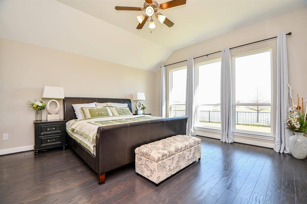 Primary suite with wood floors and lakeside views