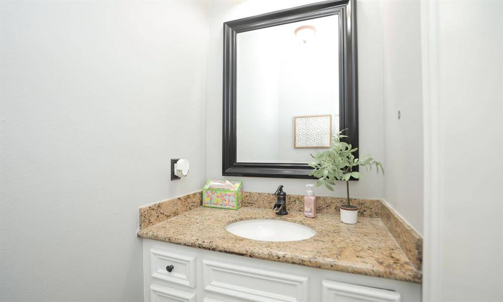 The 1/2 bath features granite counter and elegant fixtures.
