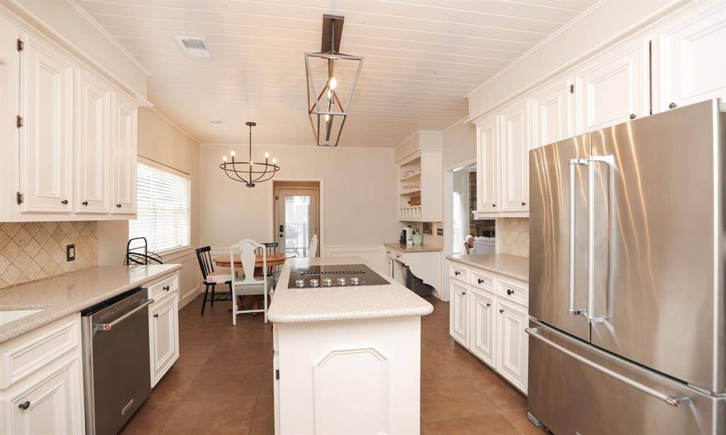 The neutral-toned countertop and backsplash complement the classic design, while a large window provides natural light.