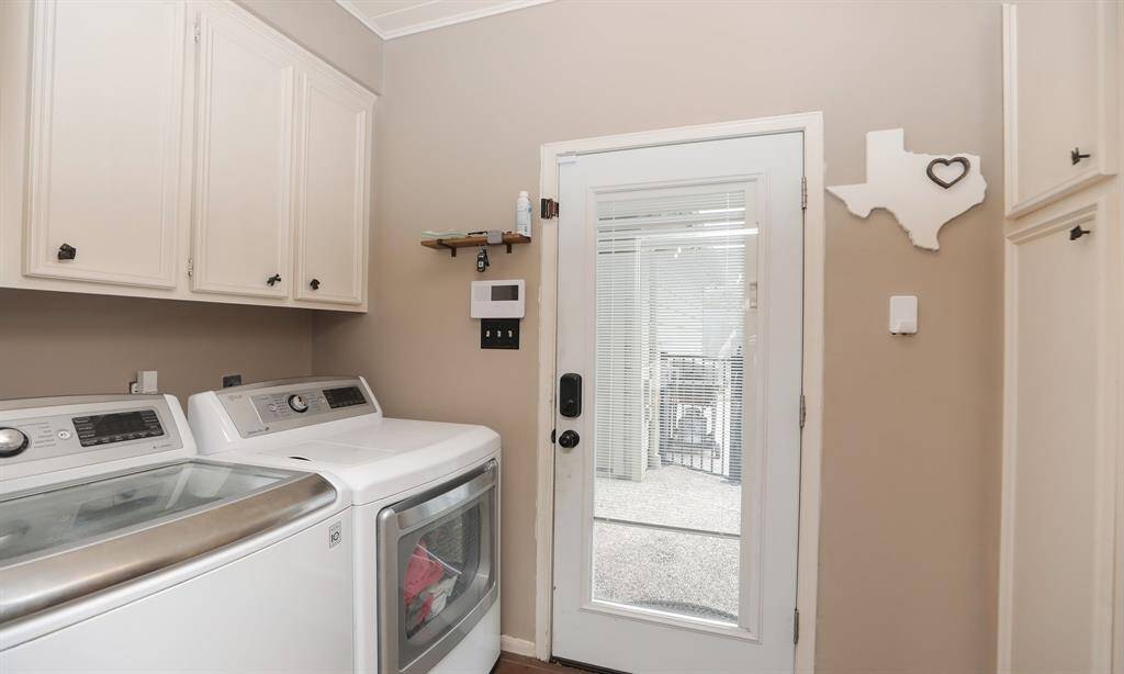 The laundry room features neutral walls cabinetry, and a door leading to the backyard.
