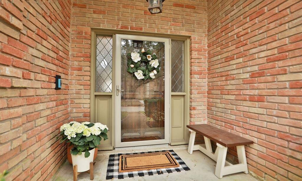 A welcoming wooden entrance with a glass storm door.