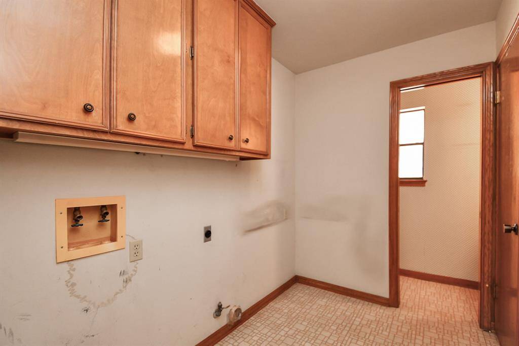 Laundry room with space for extra fridge or freezer, also features additional storage closet and powder bath. Plenty of space here to build in your mud room if desired.