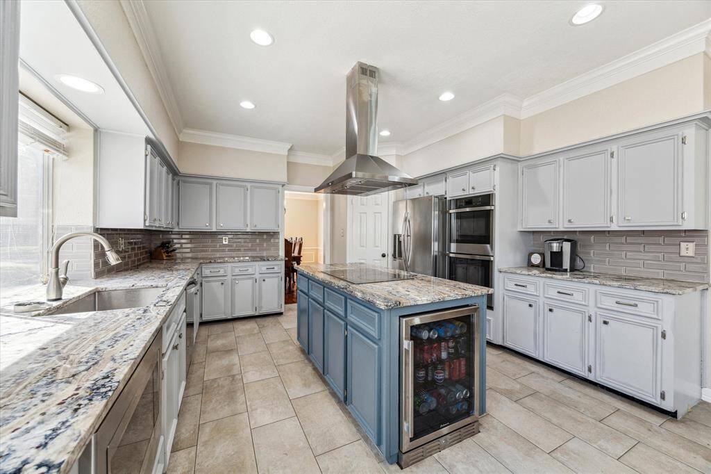 A large window over the sink allows for abundant natural light, enhancing the bright and airy feel of the space. The durable tile flooring adds a touch of sophistication while ensuring easy maintenance.