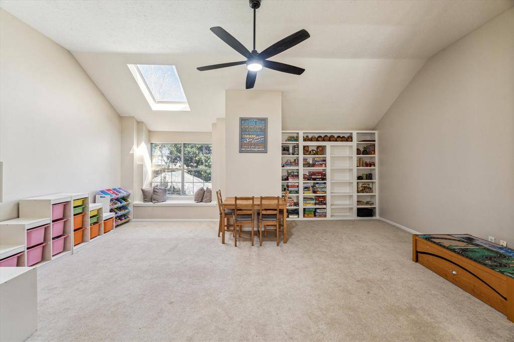 The extra space in this game room offers built-in shelving, a cozy window seat, and a skylight that fills the space with natural light. With  ample storage, it’s the perfect area for play, home school study, or relaxation.