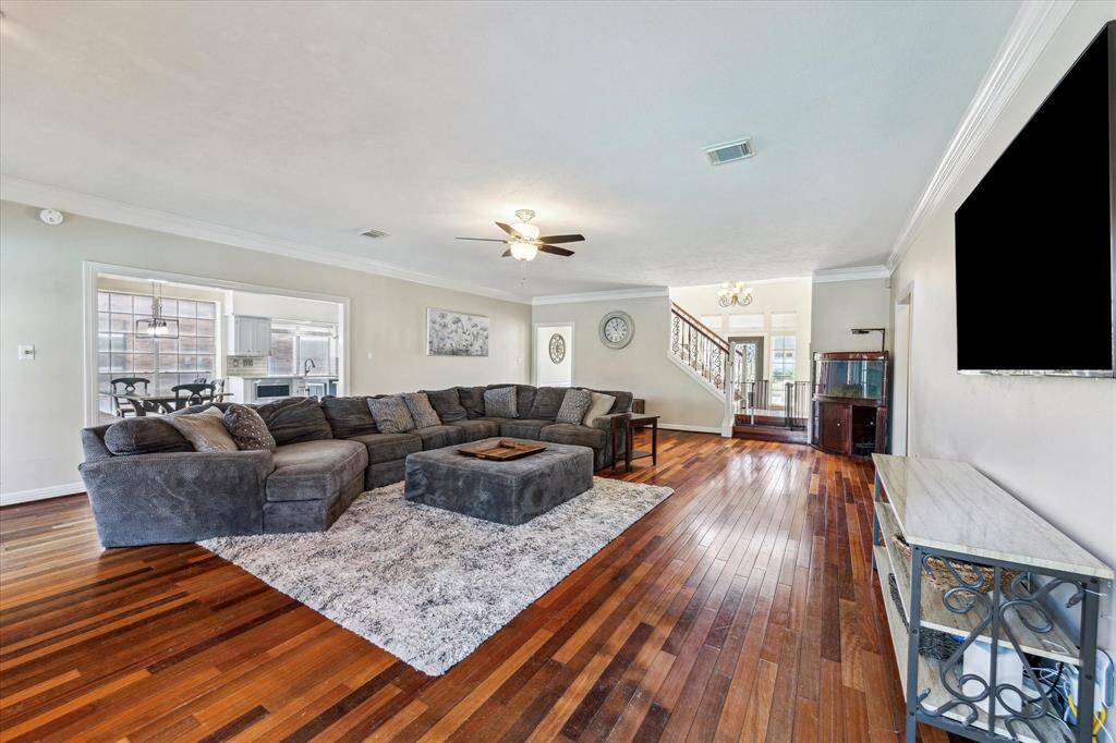 This expansive living room offers a perfect blend of comfort and style with an open layout that seamlessly connects to the kitchen and breakfast area.