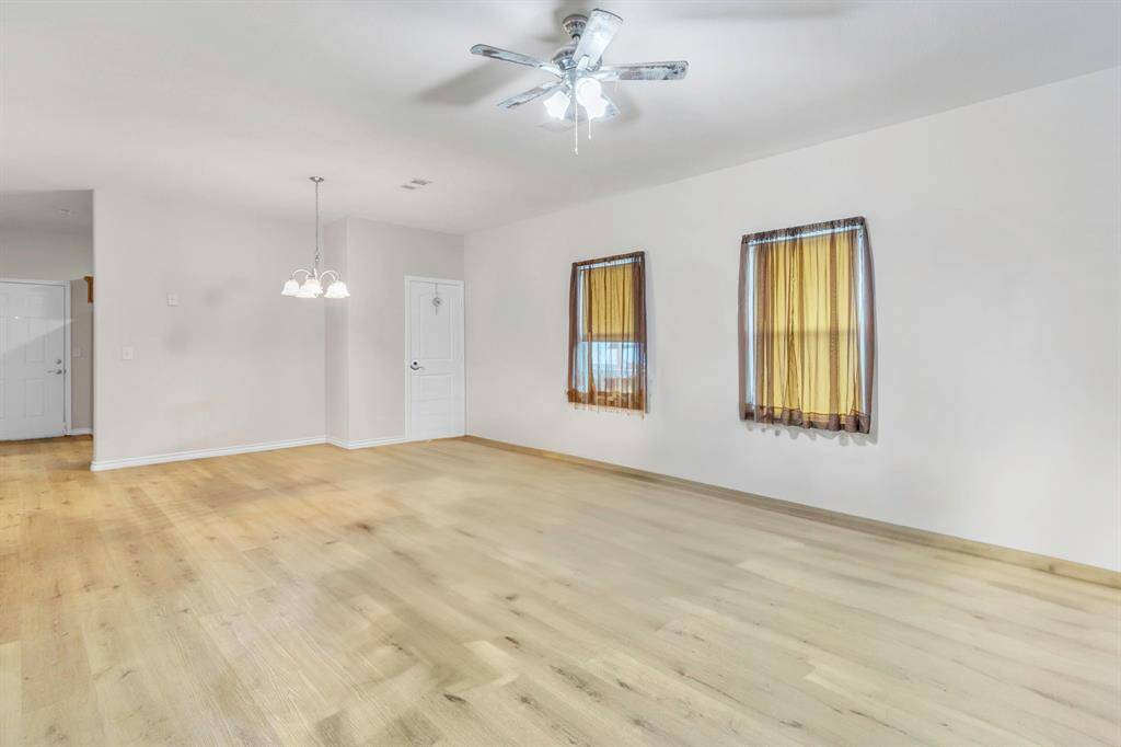 Bright and spacious combined living and dining area with elegant plank flooring and abundant natural light.