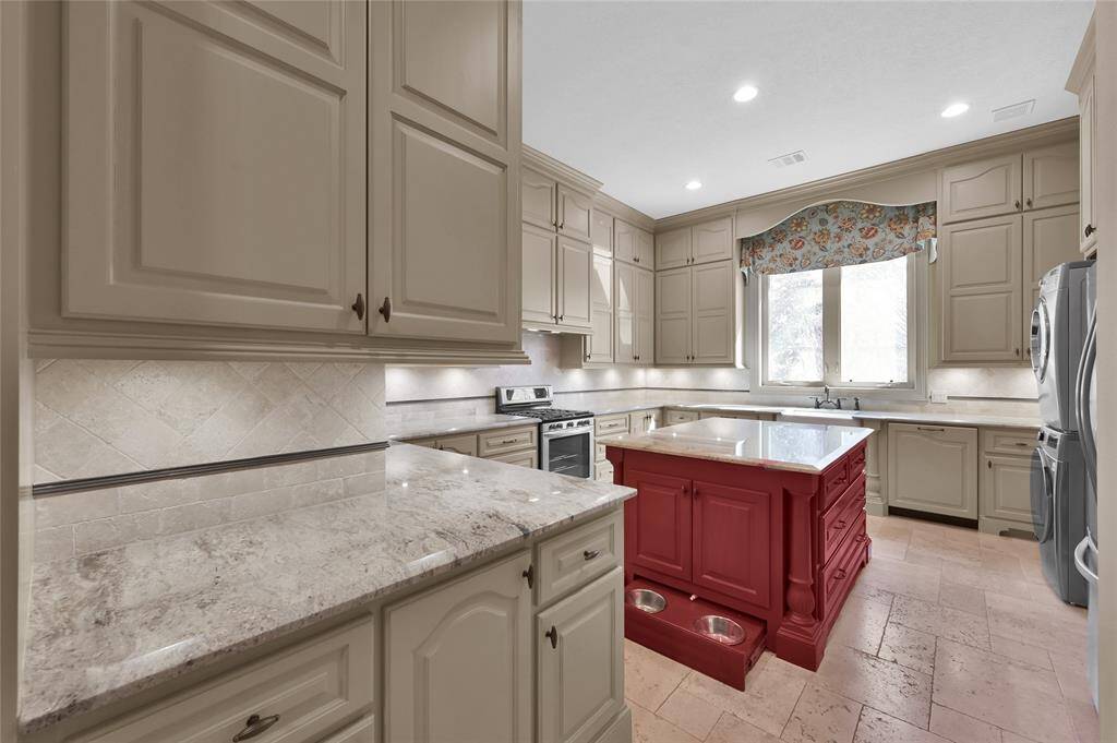 The prep kitchen with a full set of appliances and laundry area offers a great space for behind the scenes party preparation and clean up. Pet lovers will appreciate two hidden food stations tucked inside the oversized island!
