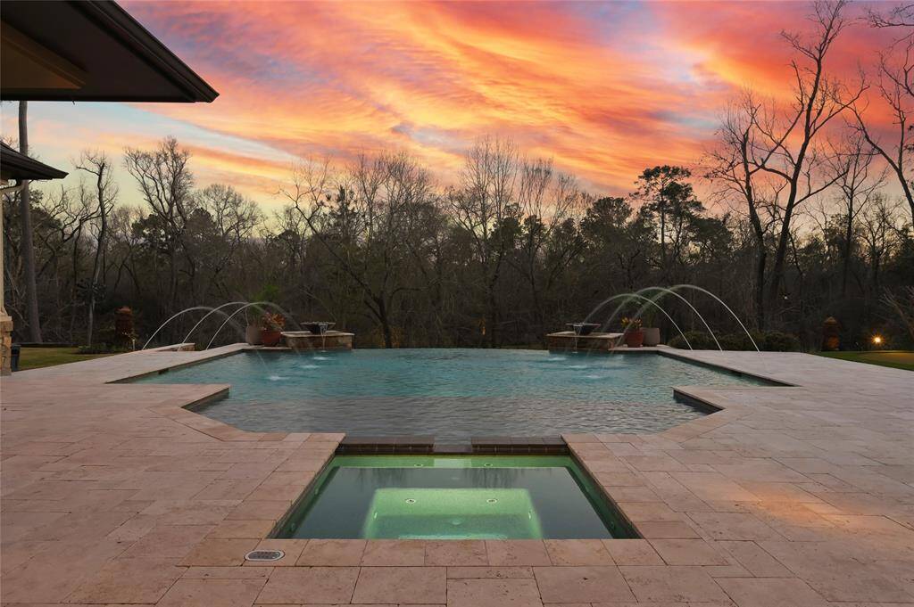 The resort-style infinity pool includes water features, heated spa, in-ground cleaner, travertine decking and million dollar views.