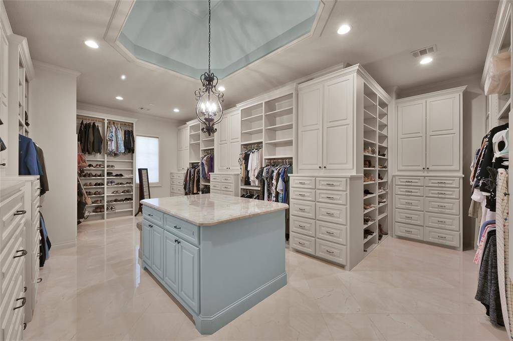 Welcome to the closet of your dreams! With built-in storage and a large center island, there is plenty of space for your wardrobe collection.