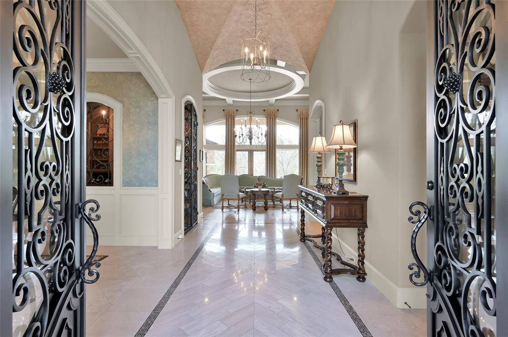 Double iron front doors welcome you into the grand foyer with marble flooring and hand-painted decorative ceilings.