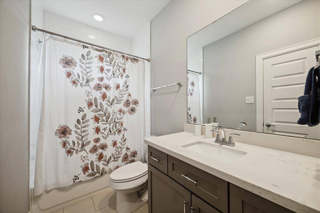 en-suite bathroom complete with shower-tub combo