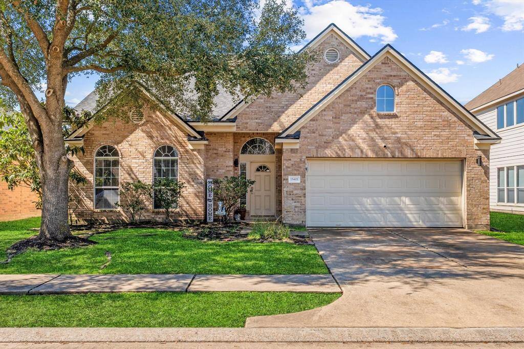 Two story hone shaded by mature oak tree.