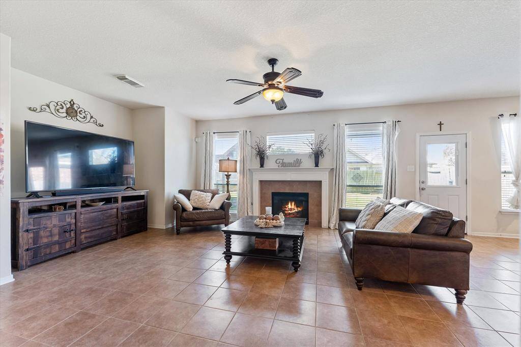 The cozy fireplace is the anchor in the living room with tile flooring and media nook