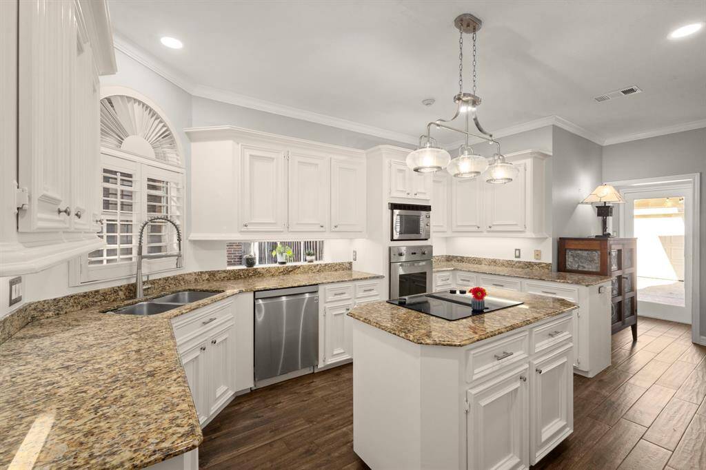 Dining room flows to the kitchen through the double doors. Shutters, chandelier and gorgeous trim/moldings are timeless.