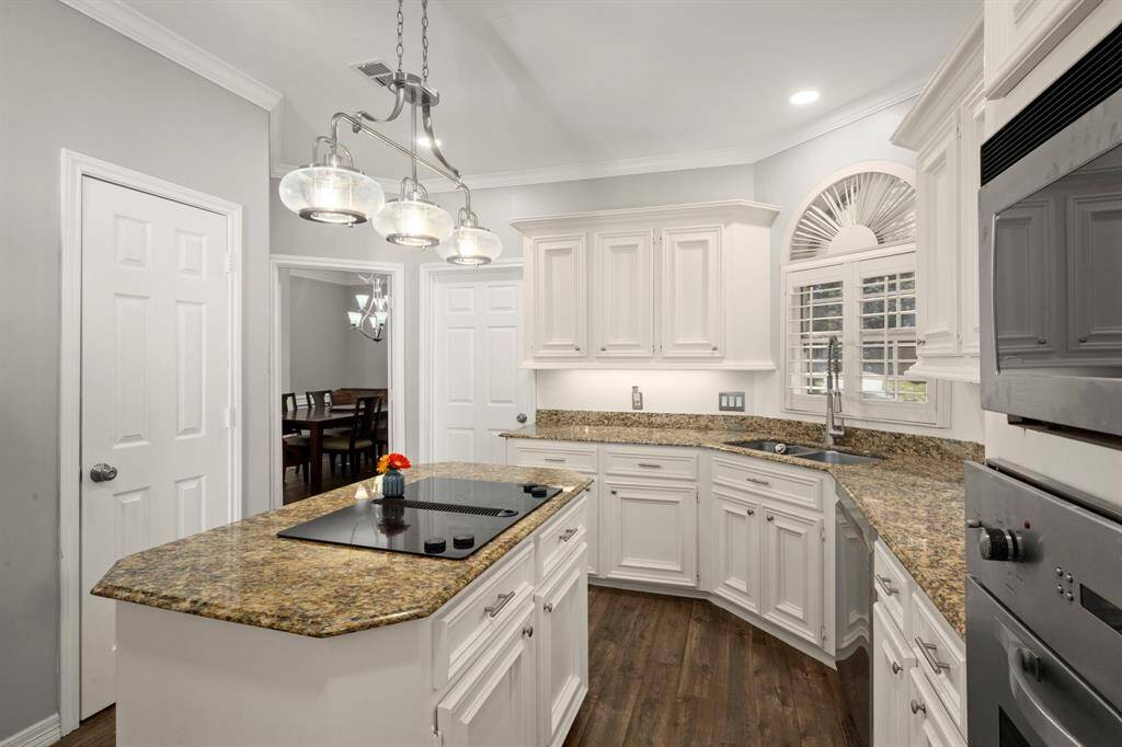 Home office sits at the front of the home for privacy and overlooks the beautiful front lawn. French doors, ceiling fan, shutters, a wall of custom cabs/shelves, and neutral paint are ready for your power meetings.