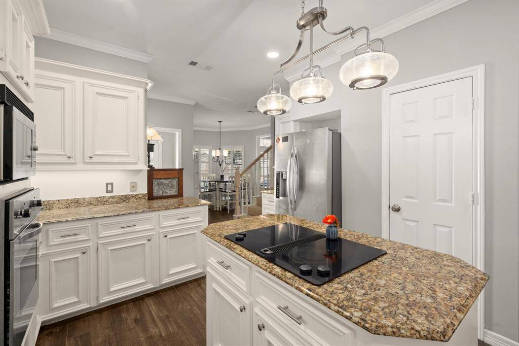 Chrome hardware, faucet, and lighting coordinate with the stainless appliances and sink.