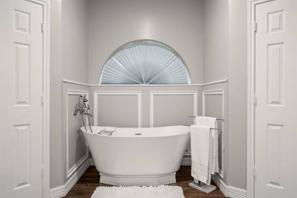 Primary bedroom offers plush carpet, ceiling fan, shutters, neutral paint and crown molding.