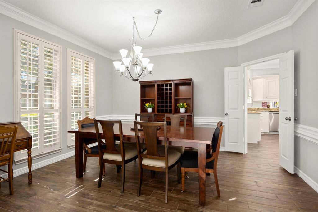 Family room is light and bright with recent floors, fireplace tiles, fresh paint, crisp white moldings, ceiling fan and recessed lighting
