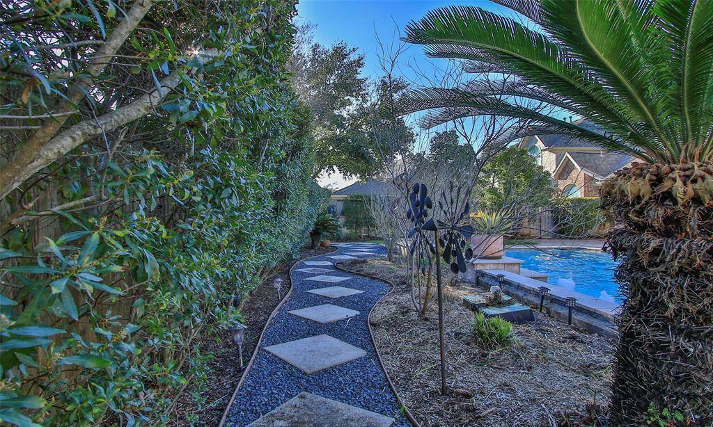 Stone walkway behind the pool makes for easy access to landscaping. Fully sprinkled. backyard offers proper drainage.