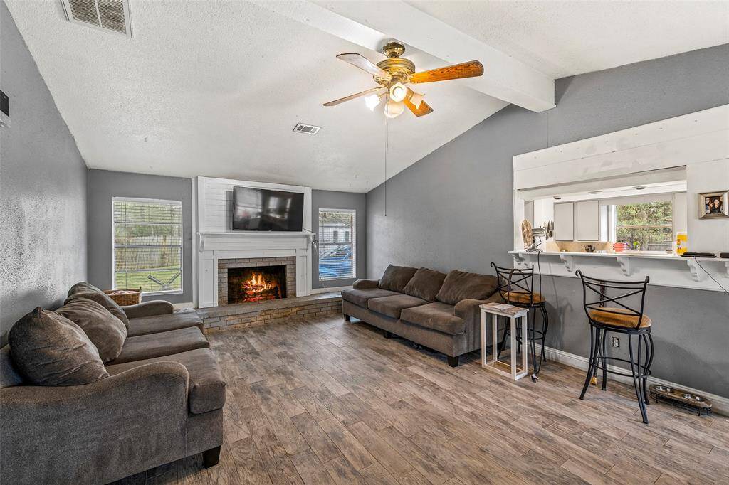 Living room features vaulted ceilings and a wood burning fireplace.