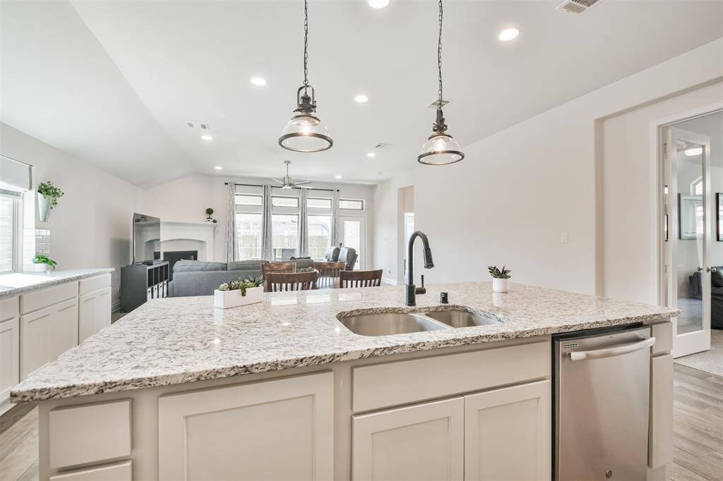 This island keeps the cook still in the middle of the action with upgraded fixtures, pendant lighting, and trash drawer.