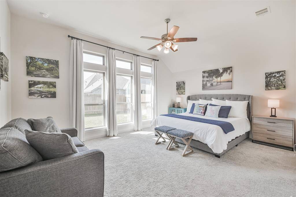 Expansive primary bedroom has enough space for a sitting area, highlighted by the natural light from the wall of windows.
