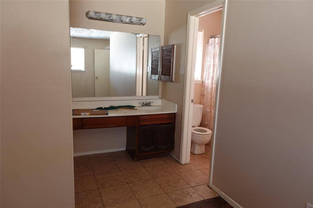 Spacious master bedroom with en-suite bathroom, featuring a large vanity and natural light.