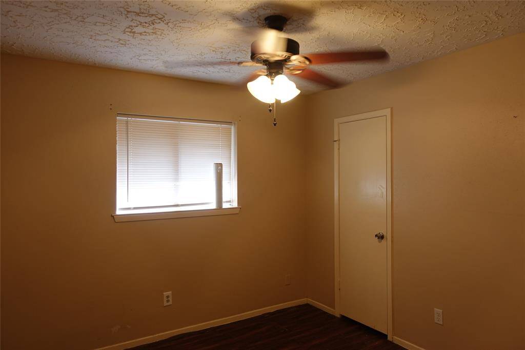 Inviting middle bedroom with cozy lighting and a ceiling fan for comfort.