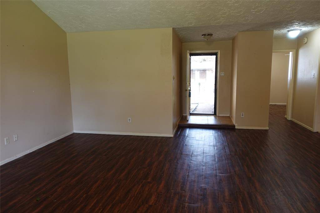 Inviting front entryway opens into a spacious living room, showcasing beautiful flooring and ample natural light.