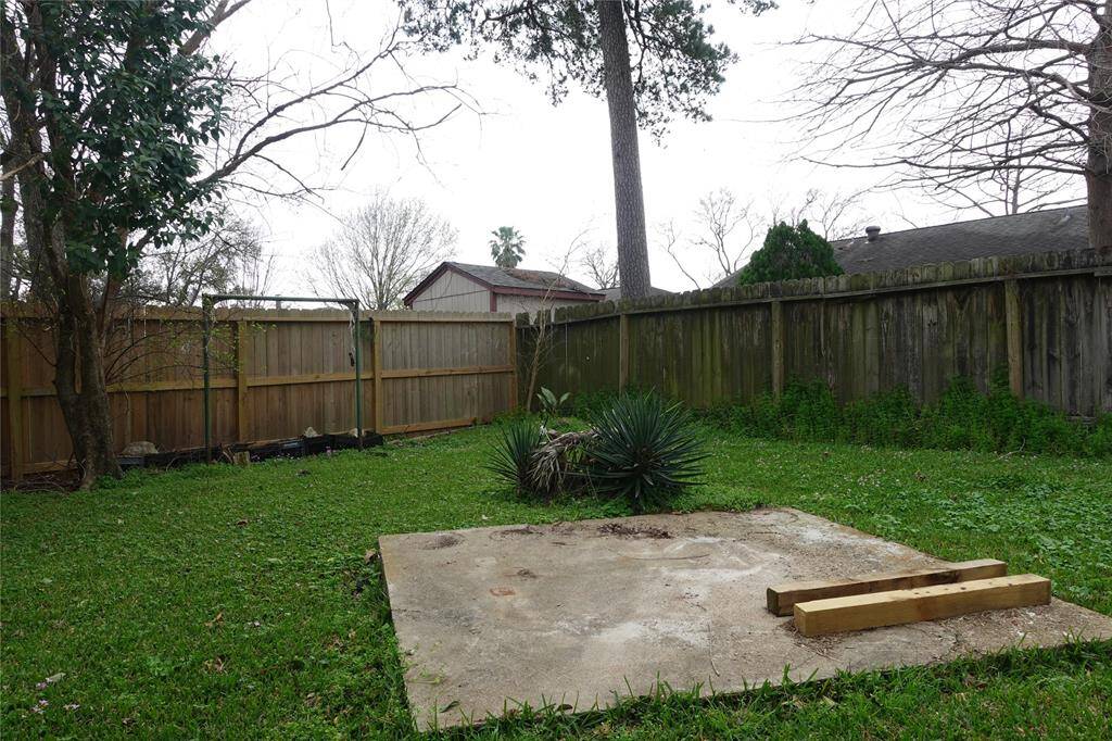 Tranquil backyard with lush greenery, mature trees, and a private fence—perfect for relaxation and outdoor activities.