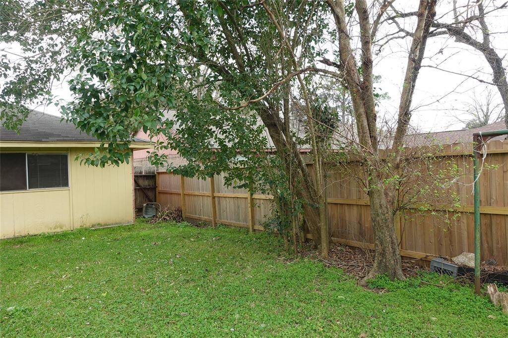 Charming side yard with lush greenery and a sturdy fence, perfect for privacy and relaxation.