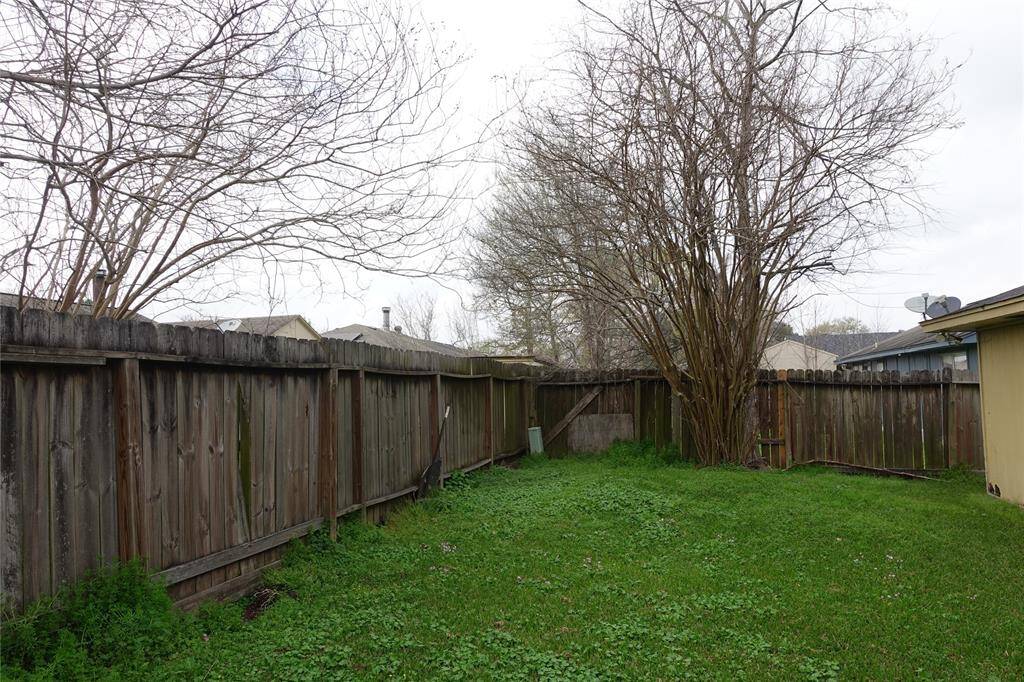 Charming backyard with lush greenery, mature trees, and privacy fencing—perfect for relaxation and outdoor activities.