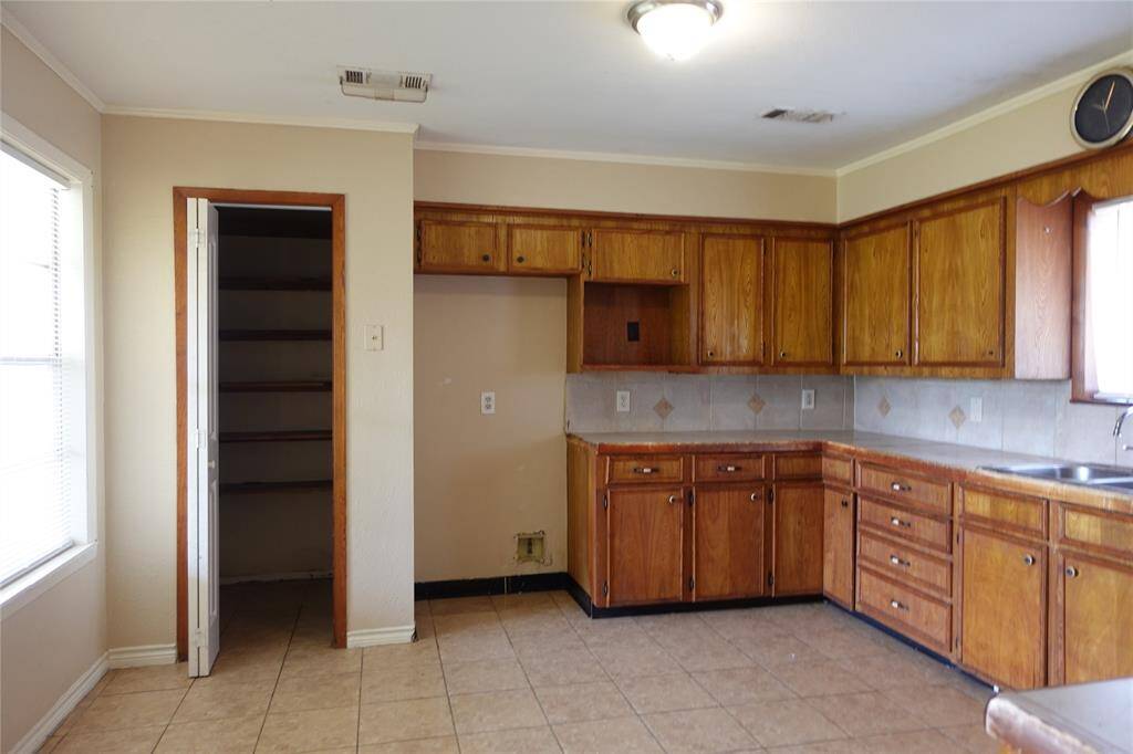 Spacious kitchen with ample cabinets and a convenient walk-in pantry, perfectly viewed from the dining area.
