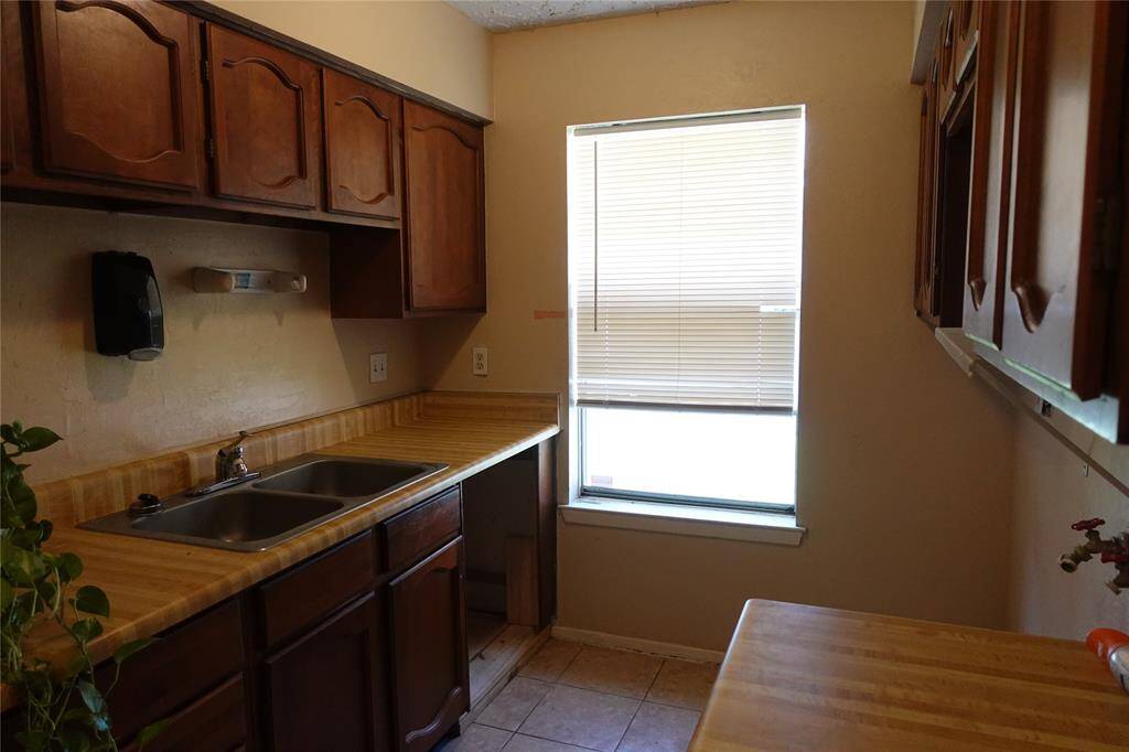Convenient laundry area featuring a sink and ample cabinet storage.