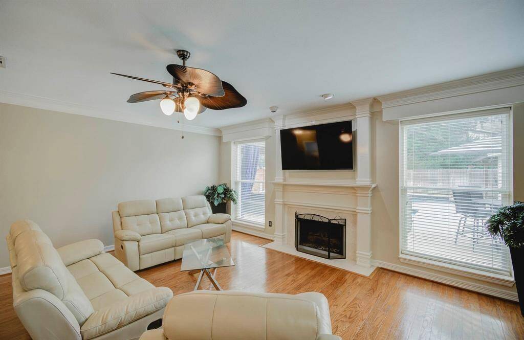 Spacious family room with hardwood floors and a cozy fireplace, perfect for entertaining.